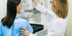 Healthcare professional assisting woman during breast screening