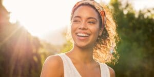 Young african woman smiling at sunset