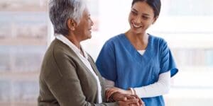 Healthcare professional and senior patient greeting each other.