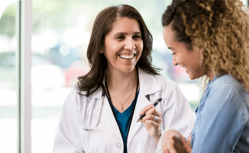 Two women having a conversation in a doctor's office.