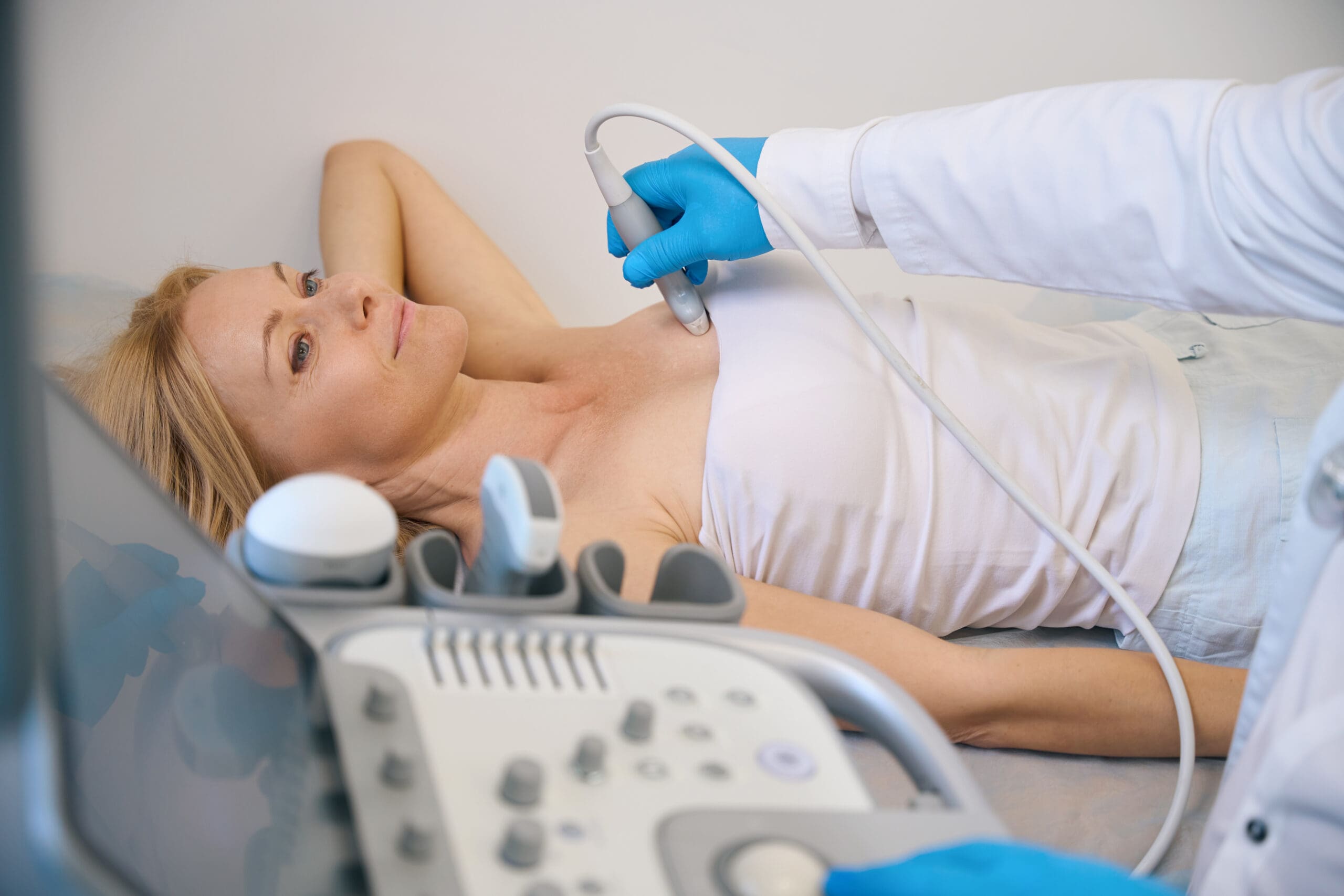 Ultrasound scanning diagnostic of woman chest in practice, a medical specialist moving ultrasonic sensor